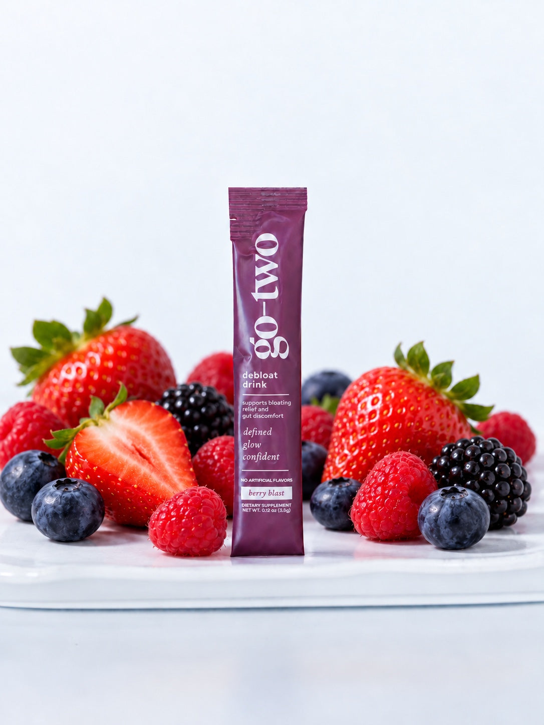 Berry Blast Debloat product image with a purple stick pack and fruit